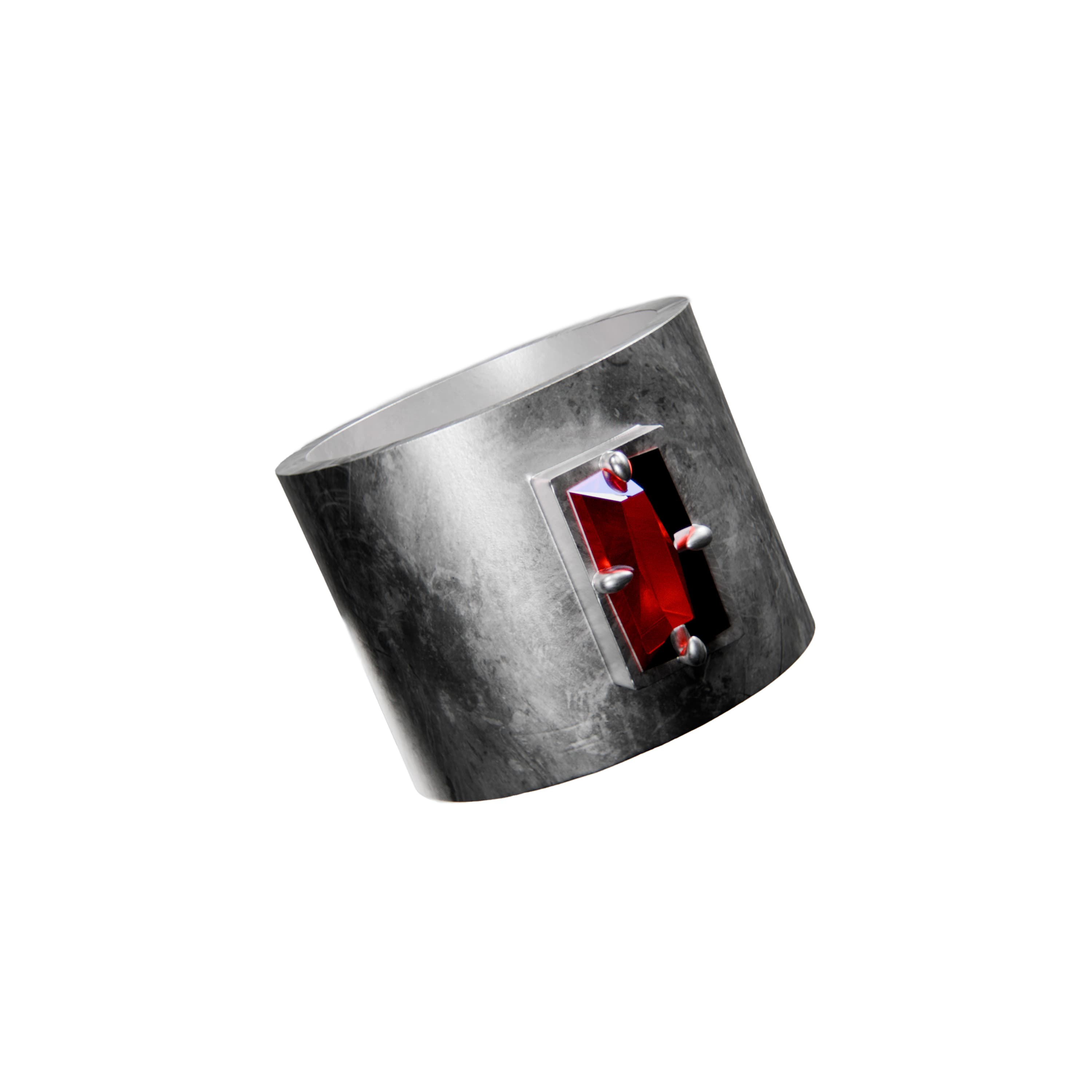 A wide silver band ring with a textured finish featuring a rectangular red garnet gemstone set in four prongs
