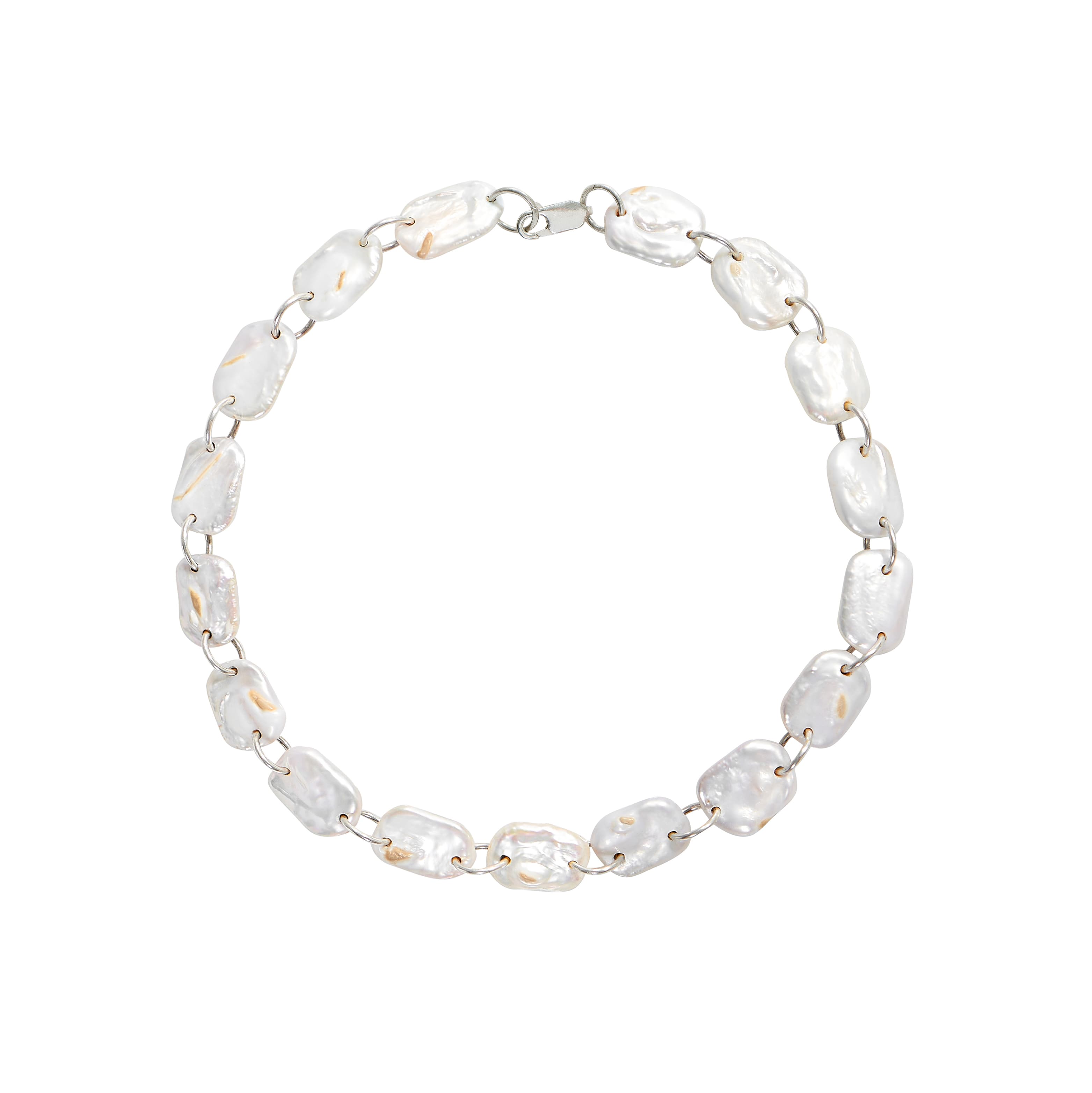 A silver choker necklace composed of flat, rectangular white pearls linked together on a white background