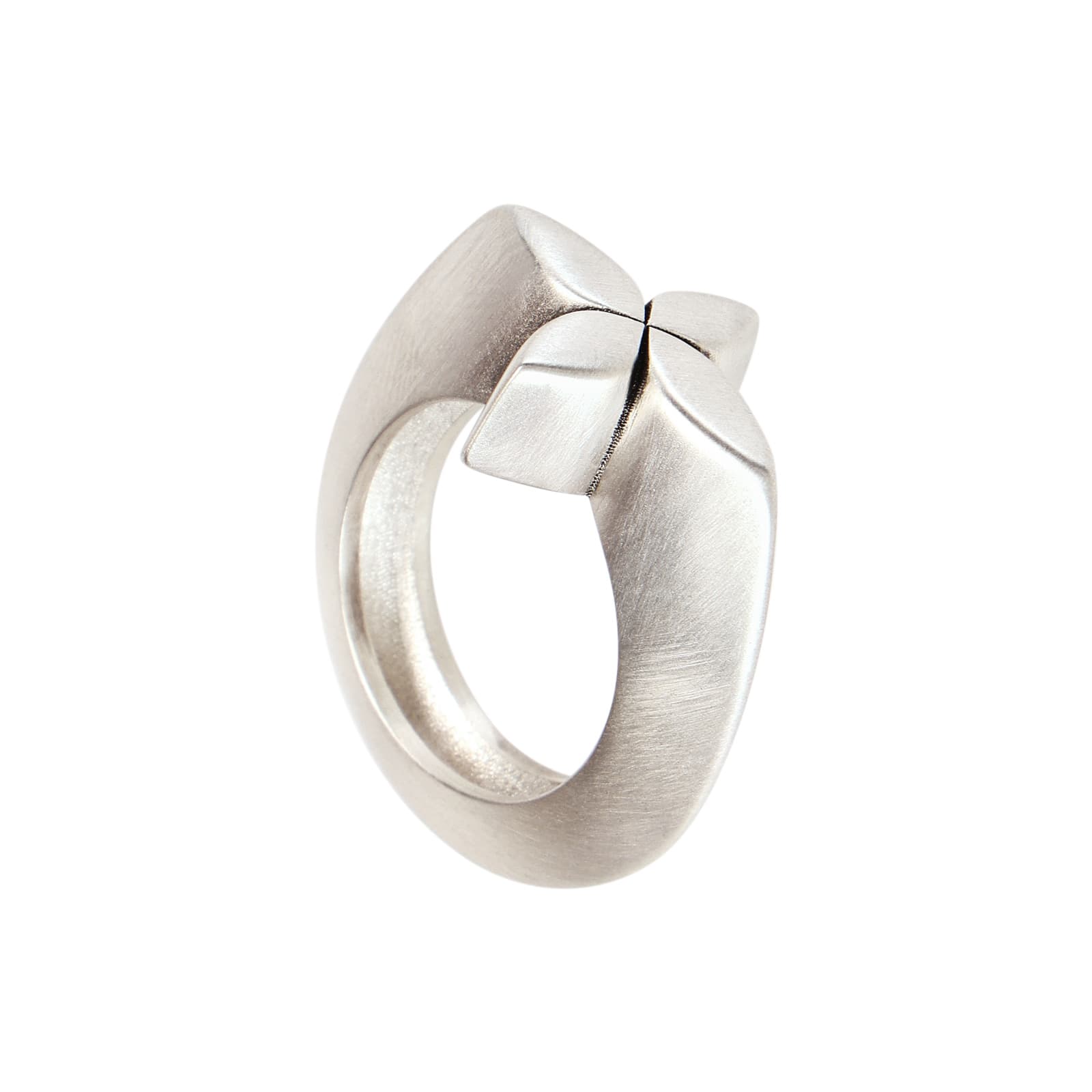 A sculptural matte silver ring with a pointed vault design resembling a four-pointed star on a white background